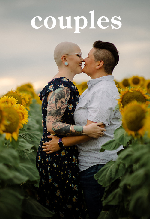 a portrait of two queer women touching noses and holding arms in a field of sunflowers