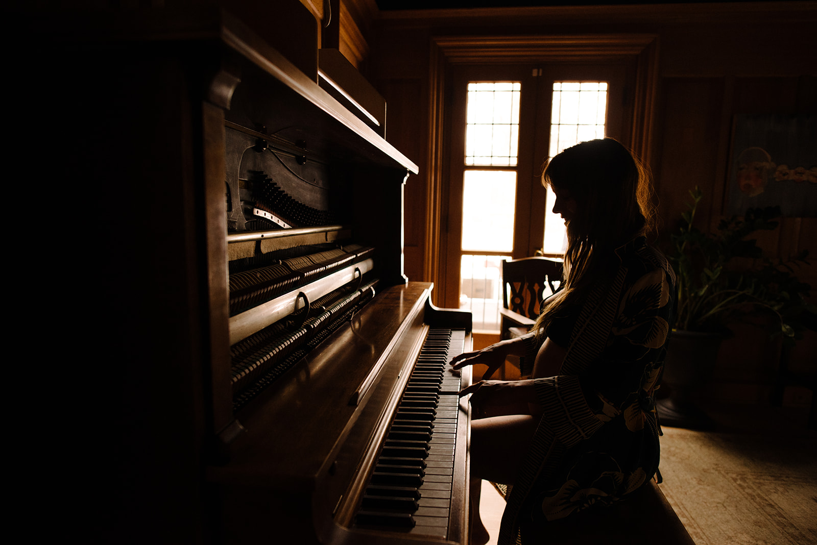 silhouette of a pregnant woman playing the piano